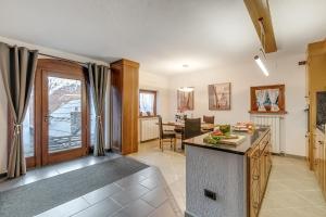 eine Küche und ein Wohnzimmer mit Tisch und ein Esszimmer in der Unterkunft Baita Dei Fiori - Happy Rentals in Bessé-Bas