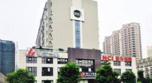 ein hohes weißes Gebäude mit einem Uhrturm darauf. in der Unterkunft Jinjiang Inn Jinhua Binhong Road in Jinhua