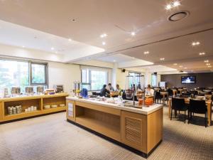 a restaurant with people sitting at tables in a room at Hotel Denim Seoul in Seoul