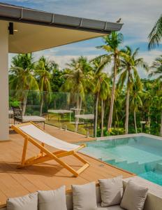 a deck with a lounge chair and a swimming pool at Treetop Bliss Villa by Sea N' Rent in Koh Phangan