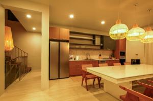 a kitchen and dining room with a table and chandeliers at Treetop Bliss Villa by Sea N' Rent in Koh Phangan