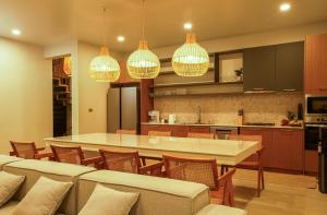 a kitchen and dining room with a table and chairs at Treetop Bliss Villa by Sea N' Rent in Koh Phangan +17 photos