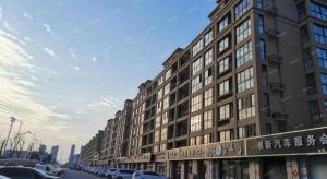 a large building on a city street with cars parked at Campanile Hotel Huaibei Yuxi in Suixi