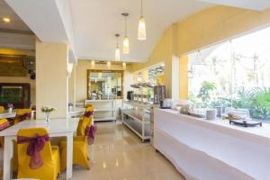 une cuisine avec des chaises jaunes et un comptoir dans un restaurant dans l'établissement Wijaya Imperial Hotel, à Demangan