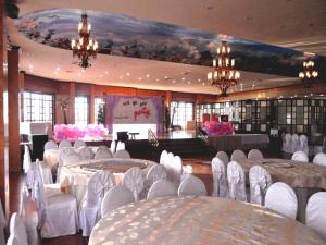 einen Bankettsaal mit Tischen, Stühlen und einem Klavier in der Unterkunft Pearlmont Hotel in Camaman