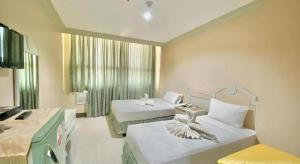 une chambre d'hôtel avec deux lits et une fenêtre dans l'établissement Cebu Northwinds Hotel, à Cebu