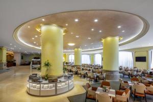 ein Restaurant mit Tischen und Stühlen in einem Gebäude in der Unterkunft Country Garden Phoenix Hotel Xinhui Jiangmen in Xinhui