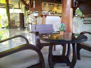 une table avec deux chaises et une table avec une plante sur elle dans l'établissement Natura Maerim Resort, à Ban Nong Pla Man (1)