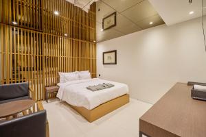 a bedroom with a bed and a desk and a chair at 컬리넌 호텔 앤 스파 in Seoul +159 photos