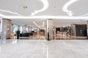 Ein Mann steht in der Lobby eines Gebäudes. in der Unterkunft International Conference Hotel Nanjing in Nanjing + 287 Fotos