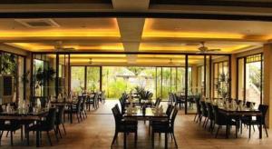 une salle à manger avec tables, chaises et fenêtres dans l'établissement Bravo Resorts - Munting Paraiso, à Dauin