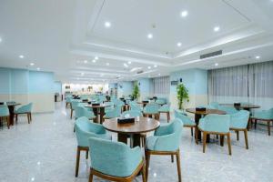 ein Wartezimmer mit Tischen und Stühlen in einem Gebäude in der Unterkunft Guilin Manhatton Hotel Tianjie in Guilin