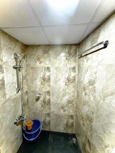een badkamer met een douche en een blauw bad bij luxury studio sector 74 in Noida