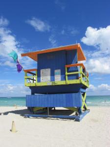 Una choza azul y amarilla de salvavidas en la playa en Ocean Breeze, en Miami Beach