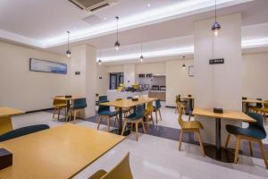 a room with tables and chairs and a kitchen at City Comfort Inn Liuzhou Diwang North Station in Liuzhou