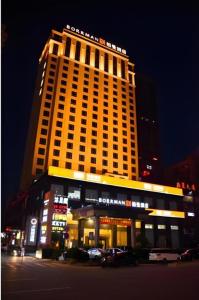ein großes gelbes Gebäude mit davor geparkt in der Unterkunft Borrman Hotel Dongguan Changping Avenue in Dongguan