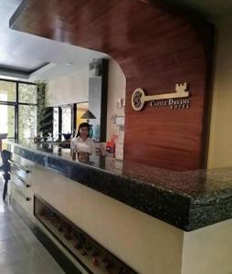 a woman standing behind a counter in a kitchen at Castle Dreams Hotel in Daliao