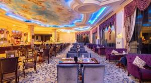 una sala da pranzo con tavoli, sedie e soffitto di Country Garden Phoenix Hotel Huangshan a Huangshan