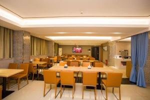 a large dining room with tables and chairs at City Comfort Inn Guigang Tangren Street in Guigang