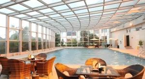 a large swimming pool with chairs and a building at Putian Haiyuan International Hotel in Putian