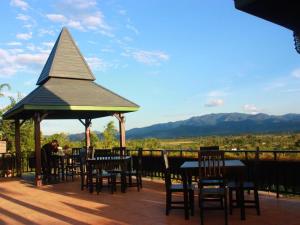 a man sitting at a gazebo with tables and chairs at Thaton Hill Resort in Mae Ai Chiang Mai