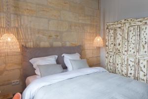 - une chambre avec un lit doté de draps et d'oreillers blancs dans l'établissement Logis de la Cadène - Teritoria, à Saint-Émilion