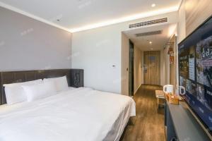ein Schlafzimmer mit einem großen weißen Bett in einem Zimmer in der Unterkunft Hanting Premium Hotel Beijing Daxing Jinxing Bridge Xingguang Film and Television City in Peking + 16 Fotos