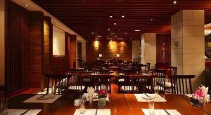 a dining room with tables and chairs in a restaurant at Man Wan Harmona Resort in Youcaopeng