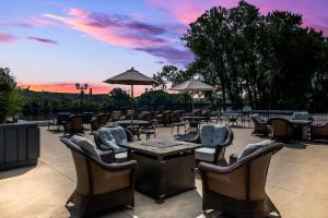 Un patio con mesas y sillas con una puesta de sol. en Radisson Hotel Grand Rapids Riverfront, en Grand Rapids