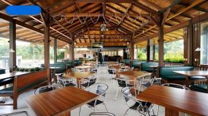 an empty restaurant with wooden tables and chairs at Jimmers Mountain Resort in Puncak