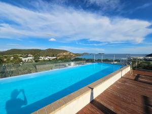 a swimming pool with a view of the ocean at F3 entier de standing tout équipé vue mer, piscine partagée et parking souterrain in Noumea +4 photos