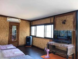 ein Zimmer mit zwei Betten und einem Flachbildfernseher in der Unterkunft Banter Resort in Ban Mai