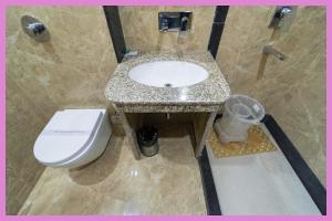 une salle de bain avec des toilettes blanches et un lavabo dans l'établissement VIP Lane MC Palace Resort - Air Conditioning Room # Best PREMIE LOCATION - Chakra Tirtha Road, Puri, à Purî