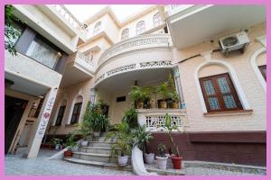 un bâtiment avec des escaliers et des plantes en pot dans l'établissement VIP Lane MC Palace Resort - Air Conditioning Room # Best PREMIE LOCATION - Chakra Tirtha Road, Puri, à Purî