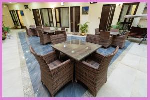un restaurant avec une table en bois et des chaises en osier dans l'établissement VIP Lane MC Palace Resort - Air Conditioning Room # Best PREMIE LOCATION - Chakra Tirtha Road, Puri, à Purî