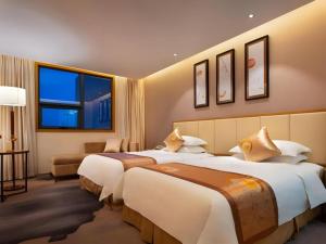 una camera d'albergo con tre letti e un divano di Fliport Garden Hotel Nanjing a NKG Altre 109 foto