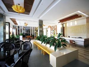 a room with chairs and a table with a bench and plants at Mango Sea View Hotel in Sanya +213 photos