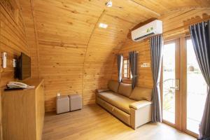 ein Wohnzimmer mit einem Sofa in einem Holzzimmer in der Unterkunft Doan Gia Resort in Cừ Lạc