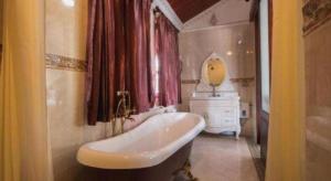 une salle de bain avec une baignoire, un lavabo et un miroir dans l'établissement The View Pavilion Hotel, à Luang Prabang 211 autres photos