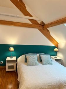 ein Schlafzimmer mit einem weißen Bett und zwei Nachttischen in der Unterkunft Apartment thermale luxeuil in Abelcourt