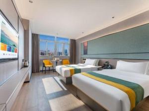 ein Hotelzimmer mit zwei Betten und einem Tisch und Stühlen in der Unterkunft City Comfort Inn Shantou Jinhu Road Branch in Changxiacun + 257 Fotos