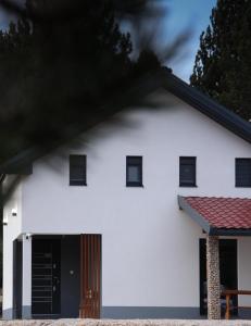 ein weißes Haus mit einer schwarzen Tür in der Unterkunft The Rest Nest in Risovac