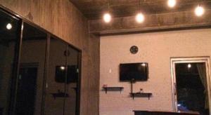 Zimmer mit einer Wand, einem TV und einem Spiegel in der Unterkunft Rim Kaeng resort in Kaeng Kachan