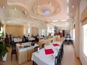 ein Restaurant mit weißen Tischen und Stühlen mit roten Servietten in der Unterkunft Sao Mai Phu My Resort in Phú Mỹ + 182 Fotos