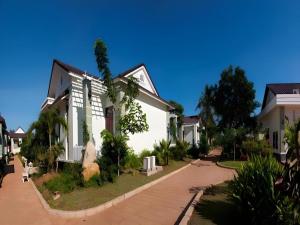 ein weißes Haus mit Bäumen und einer Auffahrt in der Unterkunft Sao Mai Phu My Resort in Phú Mỹ