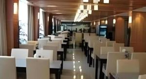 ein Esszimmer mit weißen Tischen und Stühlen in der Unterkunft Jinjiang Inn Wuhu High-Speed Railway Station West Square in Wuhu