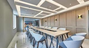 uma sala de conferências com uma mesa longa e cadeiras em Magnotel Business Shanghai Minhang Wujing East China Normal University em Xangai