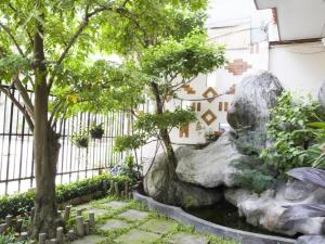 un jardin avec un rocher et des arbres dans l'établissement Spring Hotel, à Ấp An Mỹ