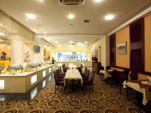 ein Restaurant mit Tischen und Stühlen und eine Bar in der Unterkunft Dunhuang Grand Soluxe Hotel in Dunhuang