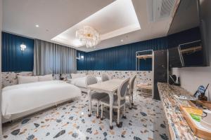 ein Hotelzimmer mit zwei Betten und einem Tisch und Stühlen in der Unterkunft Daegu February Hotel Lions Park in Daegu